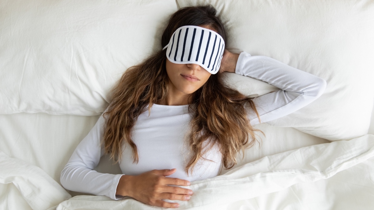 woman asleep in comfortable bed with eye mask on